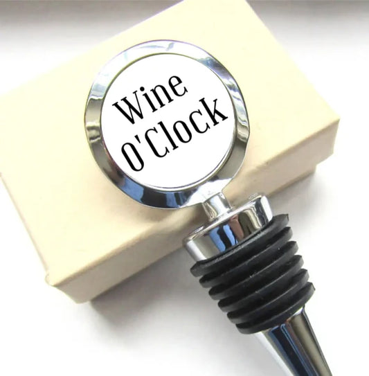 Stopiwr Potel 'Wine O’Clock' mewn golwg agos wrth ymyl blwch anrheg